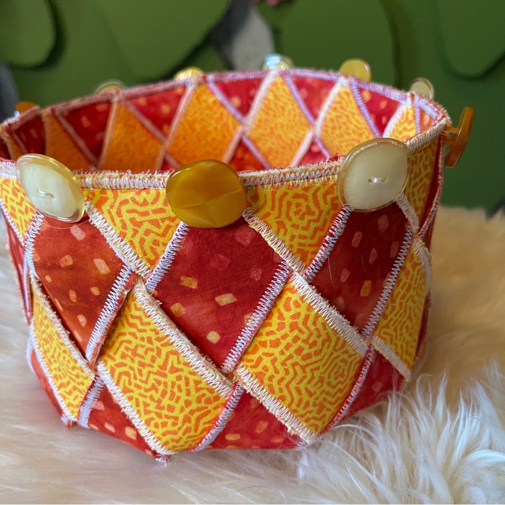 Handcrafted fabric basket. "Woven Spirals" Orange & Yellow Measures 8.5” dia